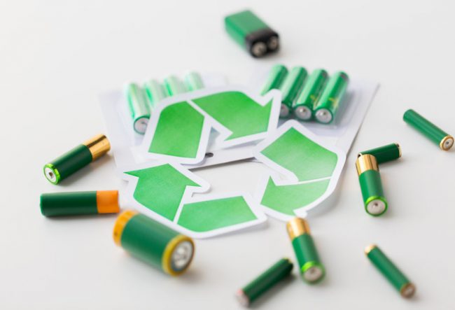 close up of batteries and green recycling symbol